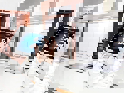 A person holds a tablet in a kitchen