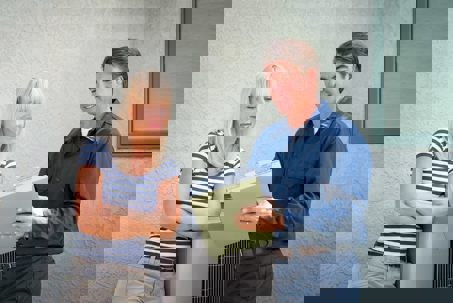 An HVAC technician reviews information with a client