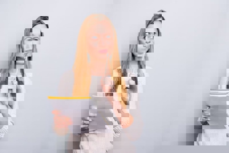 A woman thinks with a pencil to her lip.