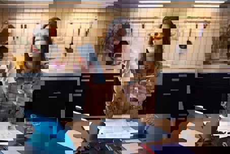 Worried woman holding phone and bills