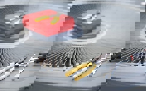 tools and a toolbox on an air conditioning unit