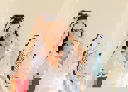 A woman is trying to cool off in front of a fan