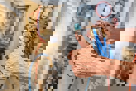 A man services an air conditioner, giving a thumbs up.