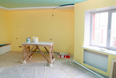 A room is being repainted; the walls are a soft yellow color