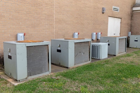 Row of industrial-sized AC units outside a brick building